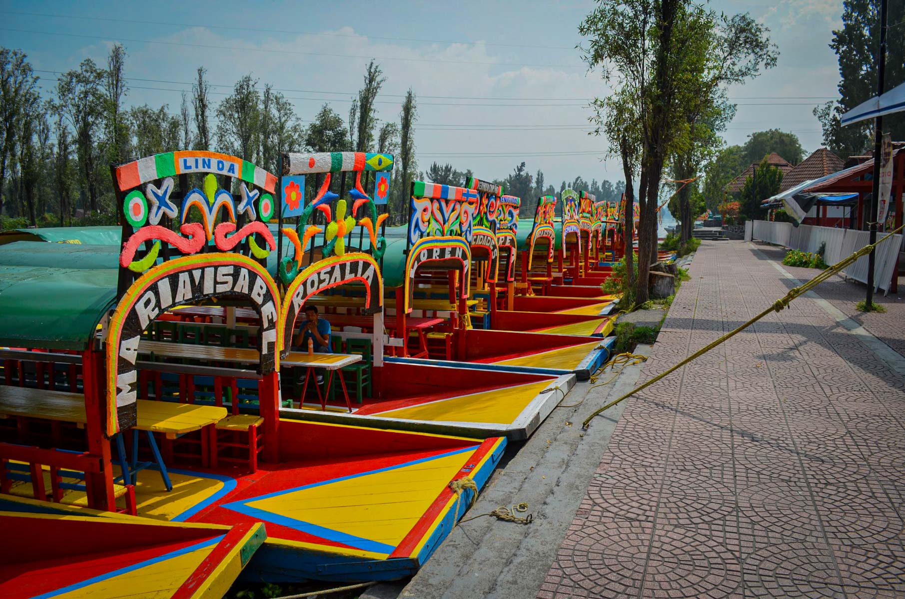 A lot of colorful "Trajineras" lined up waiting for tours around the Xochimilco Lake