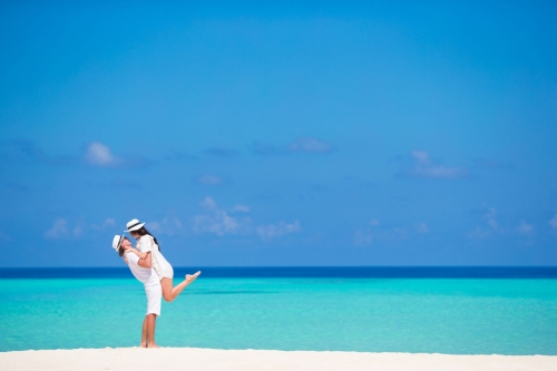 young happy couple on white beach at summer vacation